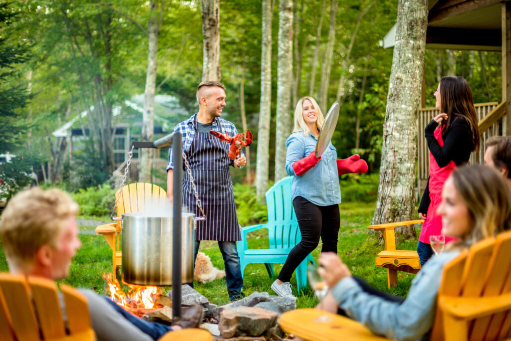 A man and a woman prepare lobster for a group of visitors at Tidal Bore Rafting Resort.