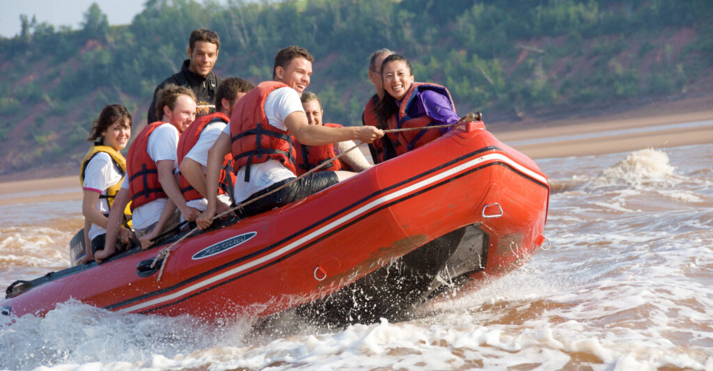 A group of rafters laughs while driving through the tidal bore rapids.