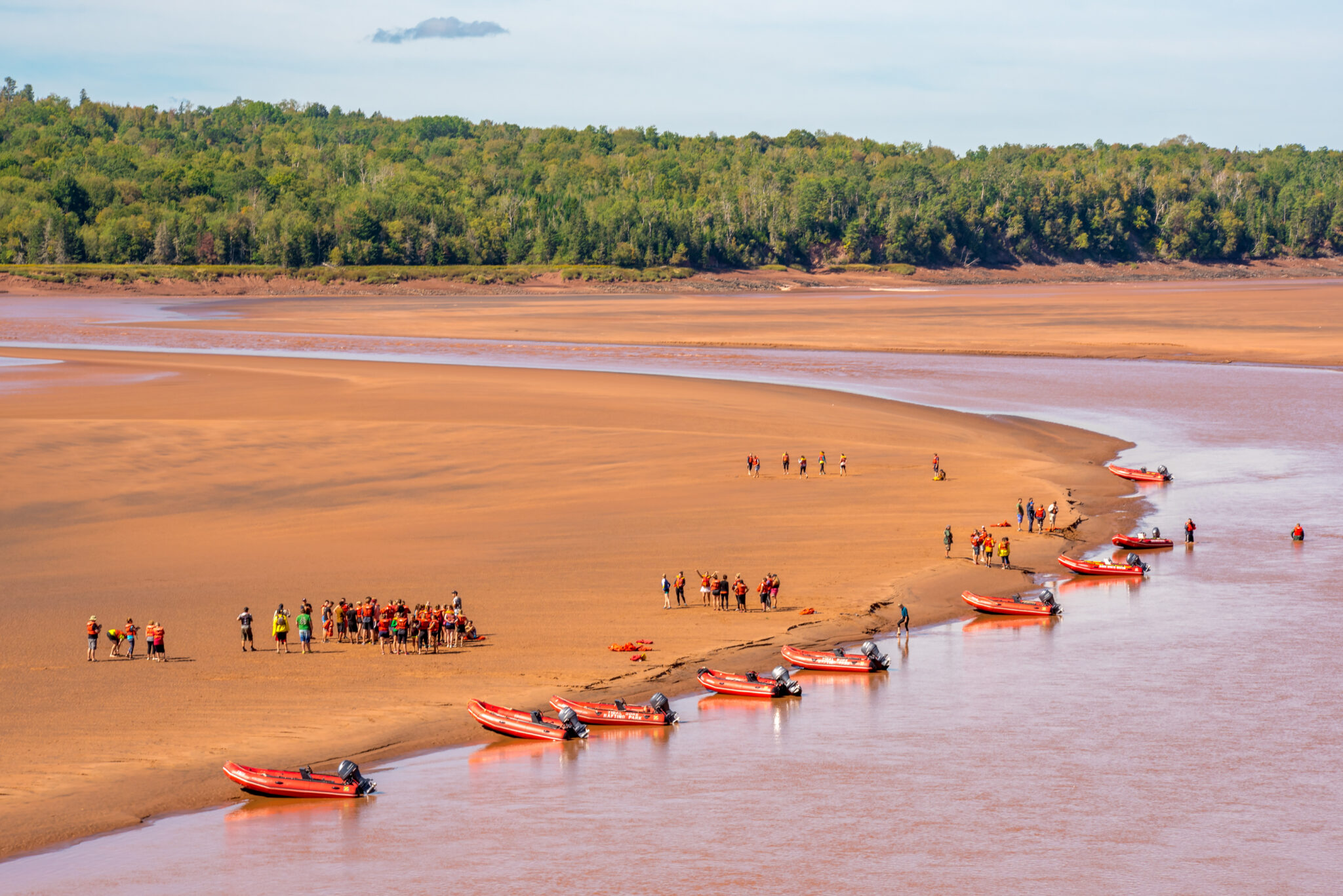 Several zodiac rafts with groups of passengers waiting at the sand bar for the arrival of the tidal bore.